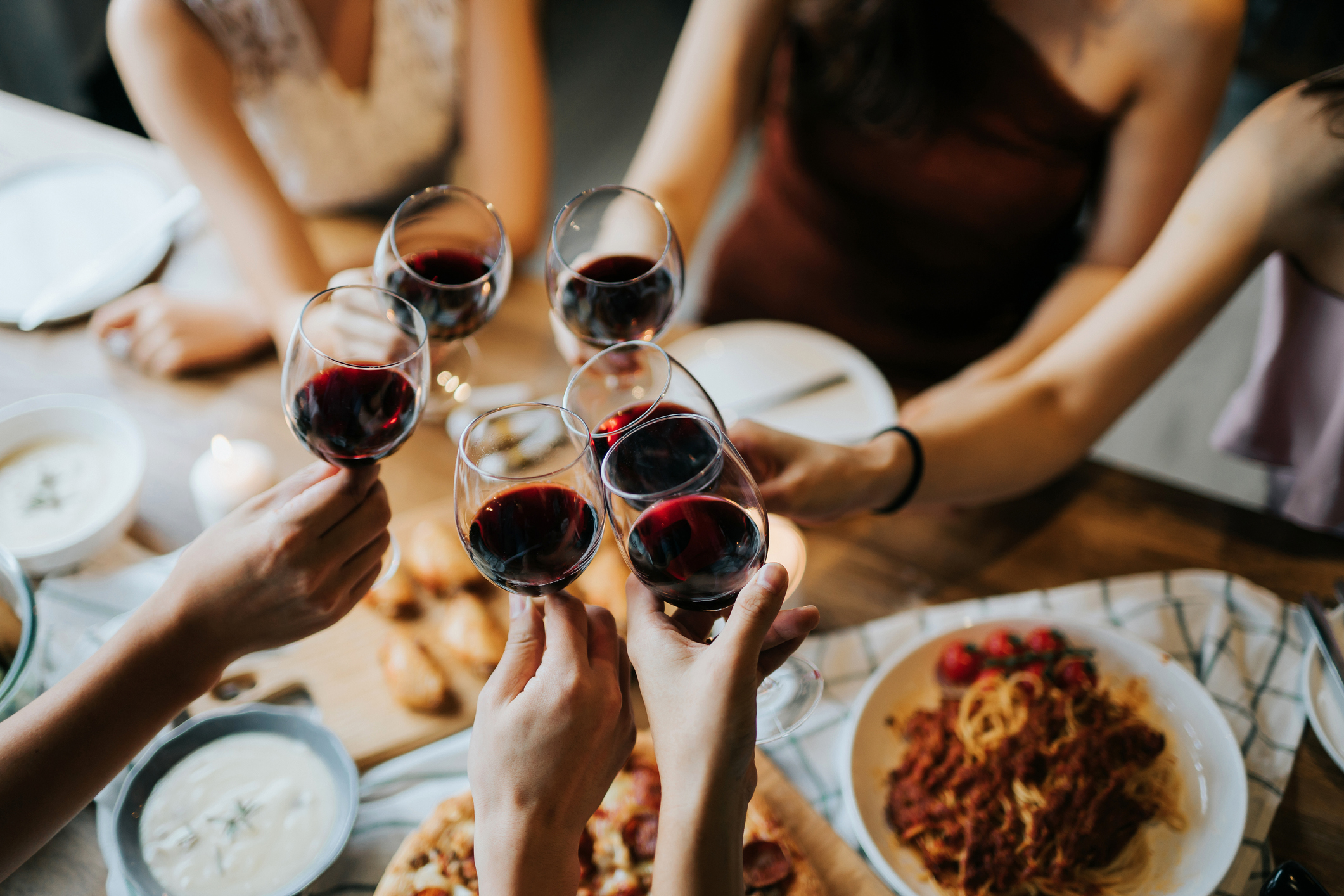 friends raising their wine glasses at dinner