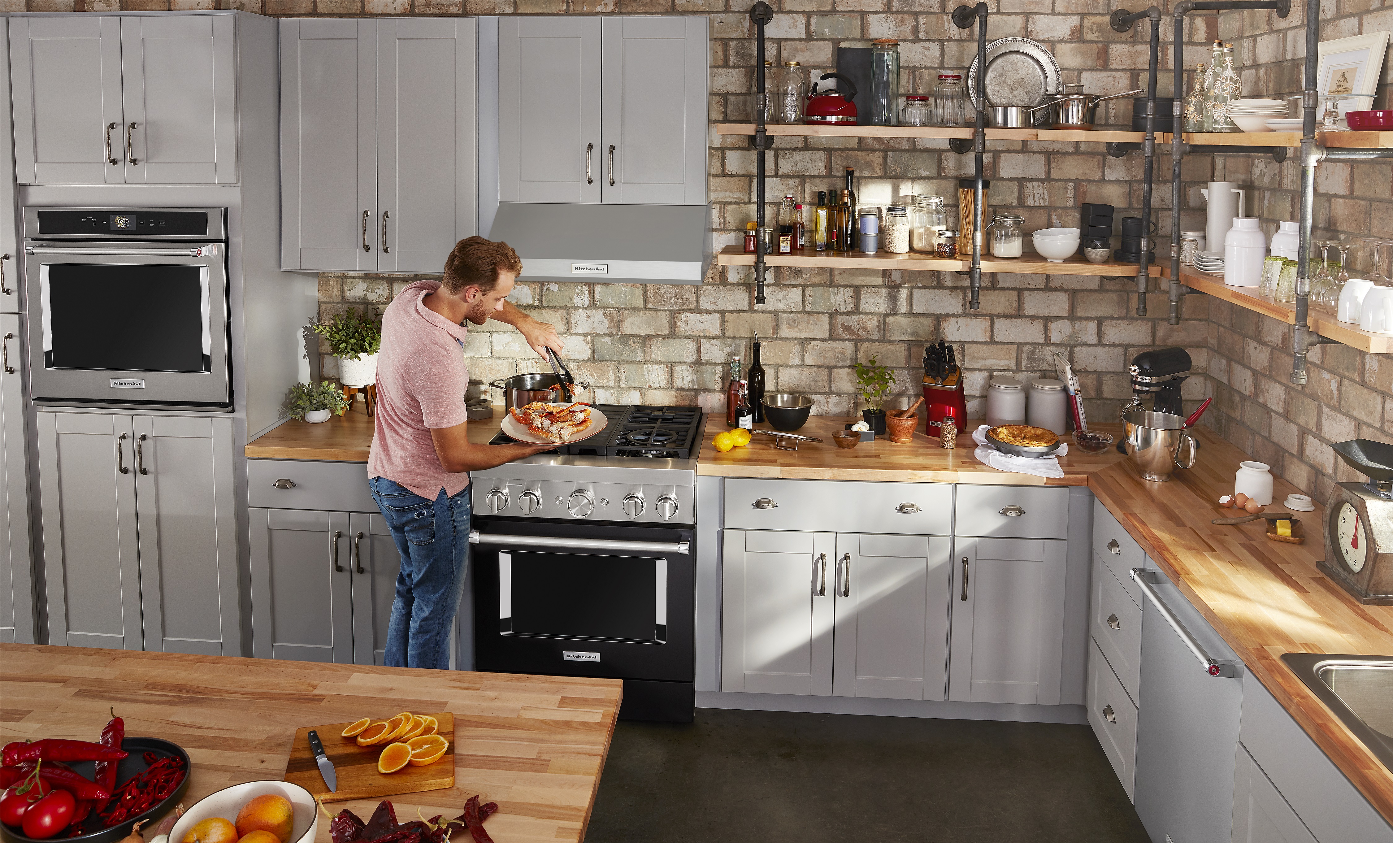 https://cdn.avbportal.com/assets/blog/blog_appliances/best-dual-fuel-range_header_kitchenaid.jpg Credit: KitchenAid man prepares meal using his KitchenAid dual fuel range