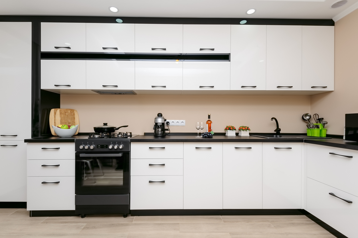 iStock Credit: Serghei Starus modern spacious kitchen with black range and white cabinetry