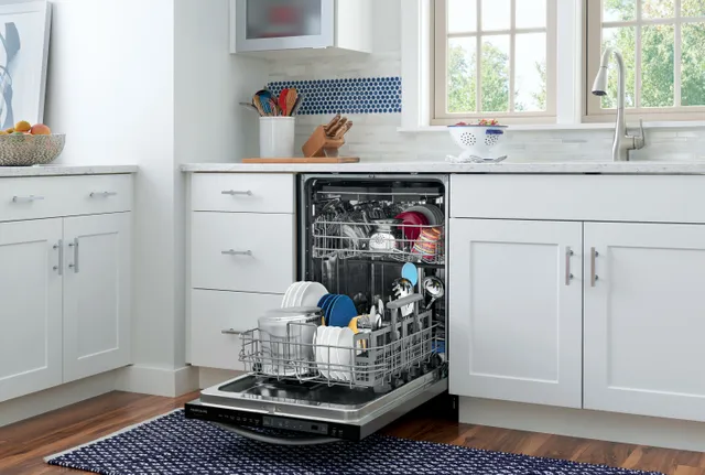 A Frigidaire Gallery dishwasher with its door open showing a full load of dishes 