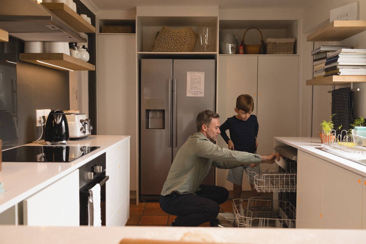 iStock Credit: Wavebreakmedia Father and son load dishes into a dishwasher