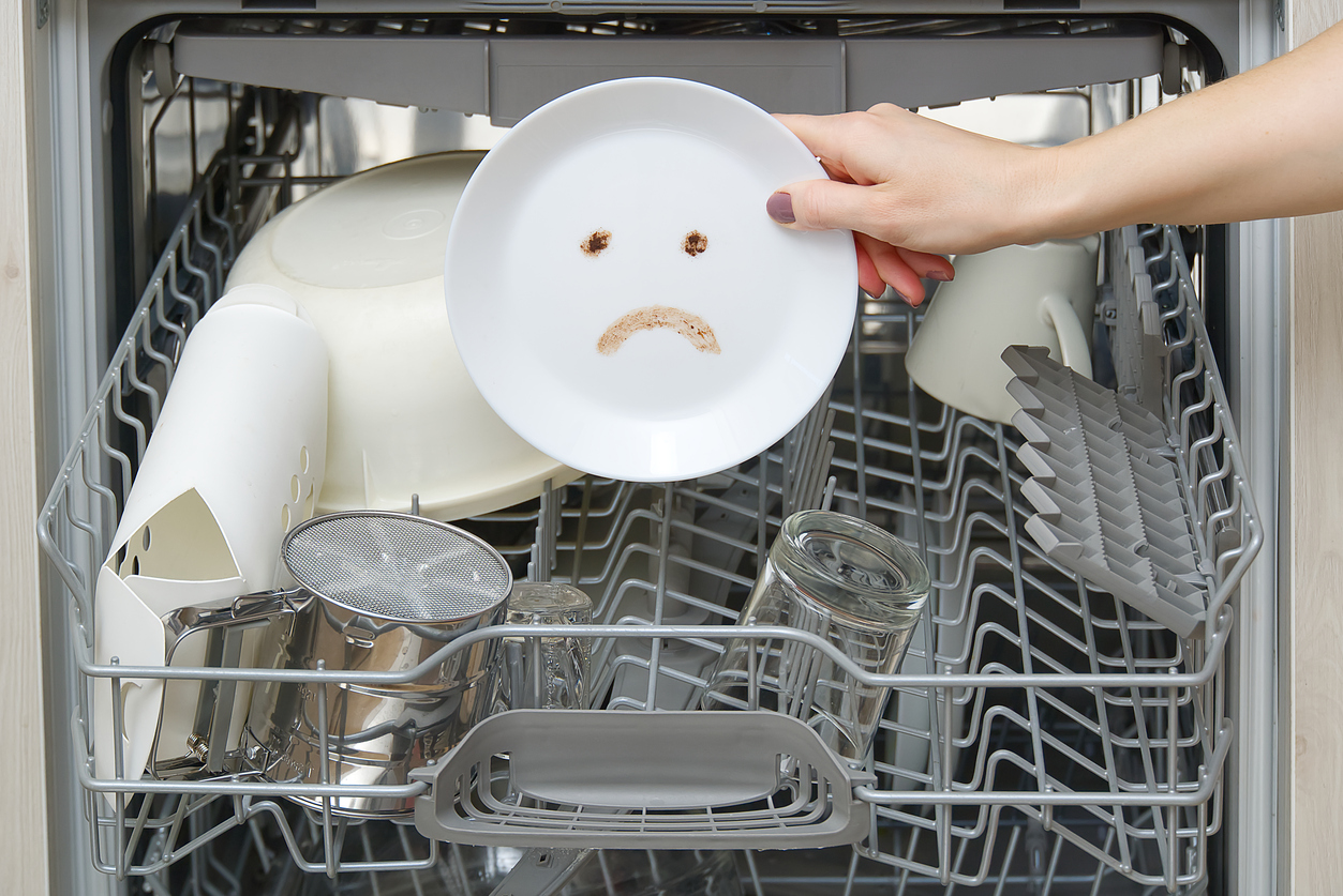 An open dishwasher with racks filled with dishes