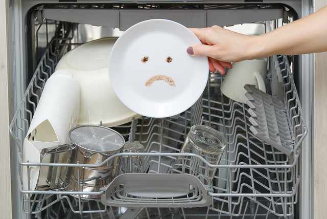 Front view of leftovers making a sad face on a plate that has come out of a dishwasher Front view of leftovers making a sad face on a plate that has come out of a dishwasher