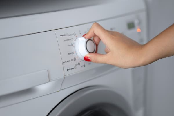 A person selecting a setting on a dryer