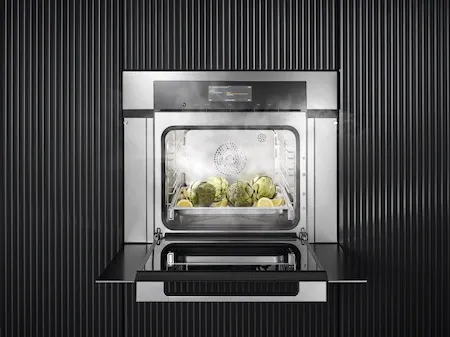 Credit: Miele The Miele DGC 7780 CTS 30” steam oven with its door open showing artichoke hearts being steamed