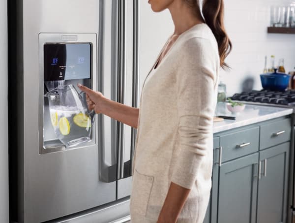 Credit: Electrolux A woman using an Electrolux water refrigerator water dispenser