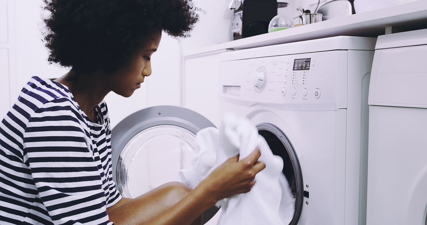 Woman takes a white garment out of a dryer