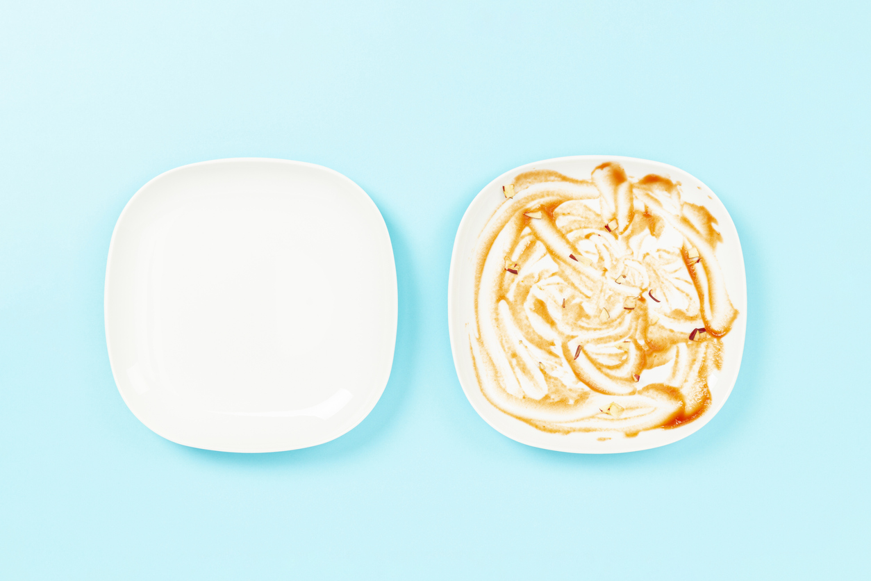 A clean and dirty plate on a  light blue background 
