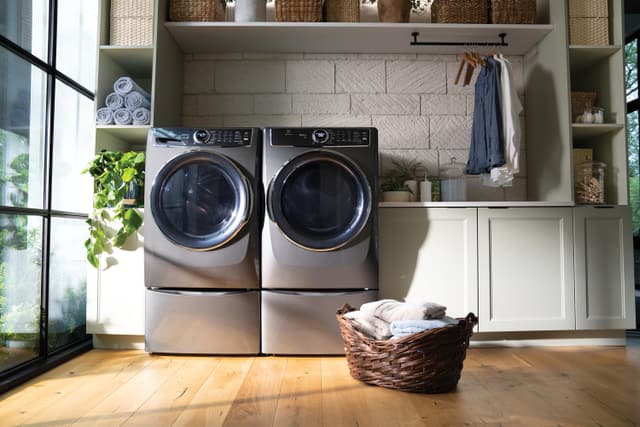A matching Electrolux washer and dryer front load washer pair in a laundry room 