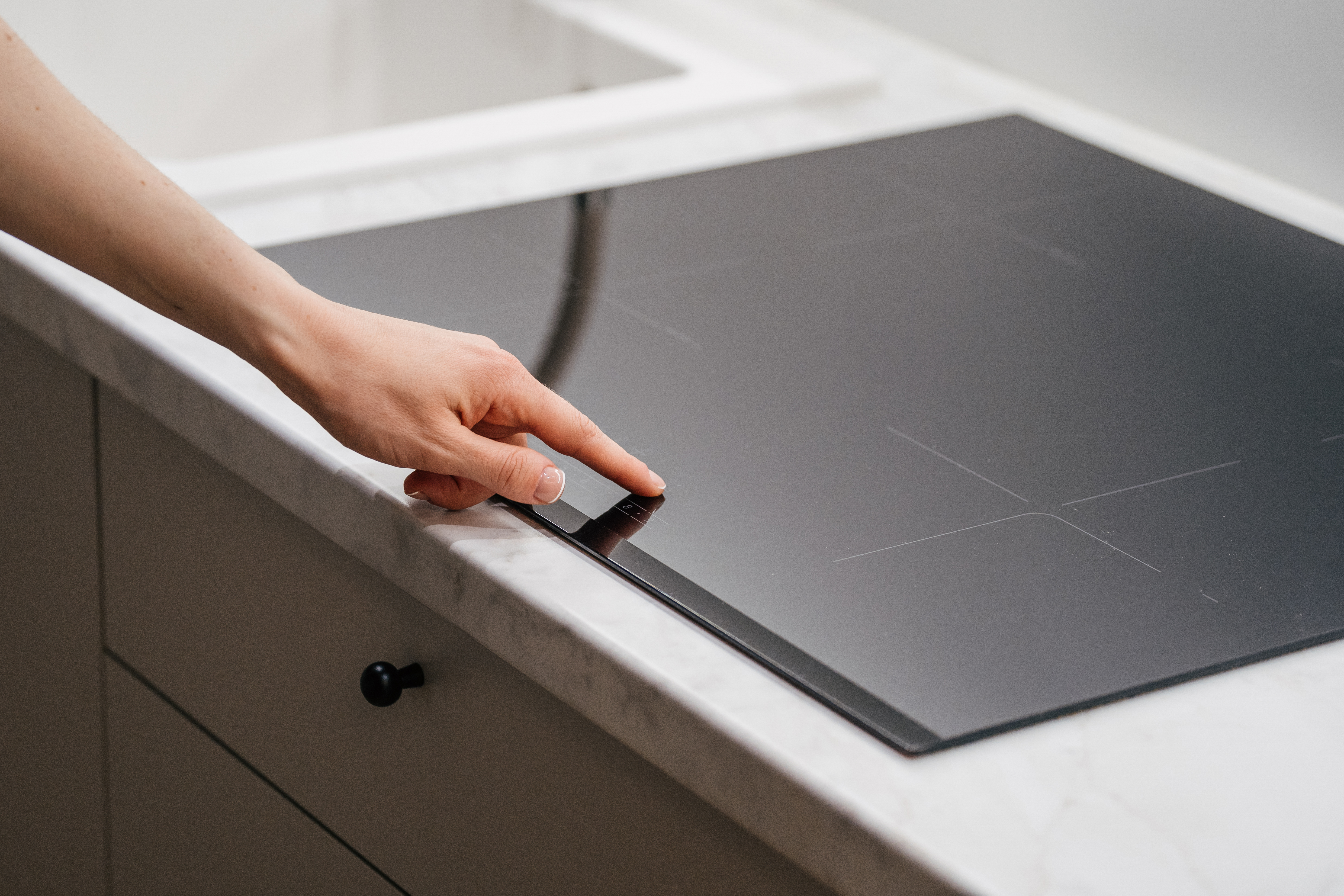 A person selecting a heat setting on an induction cooktop iStock Credit: brizmaker A person selecting a heat setting on an induction cooktop