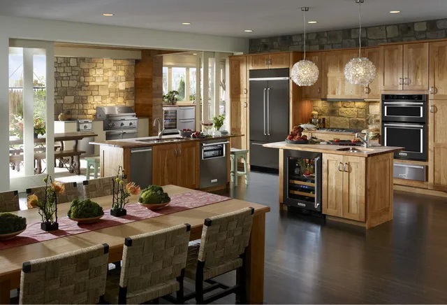 Credit: KitchenAid Warm-toned kitchen with natural wood cabinetry and a KitchenAid suite of appliances