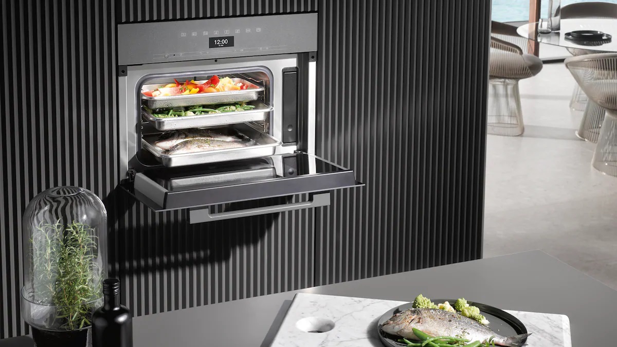 Miele An open steam oven reveals freshly steamed food