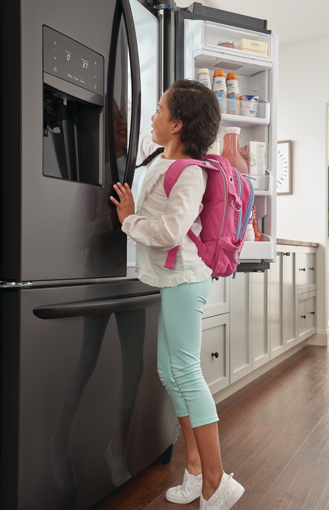 Credit: Frigidaire Images girl reaching in the fridge for a snack after school