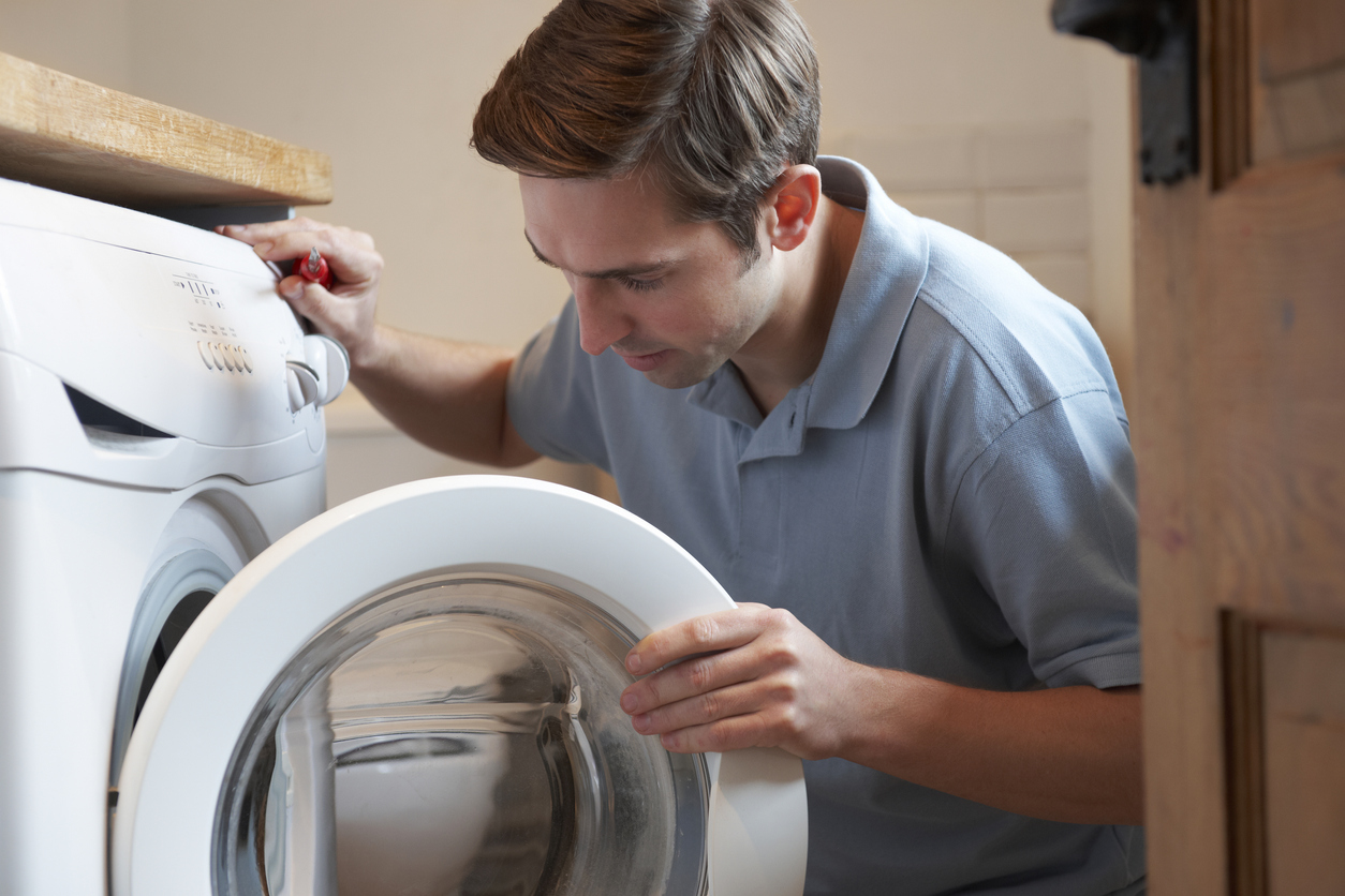 Man opens a front-loading washer door
