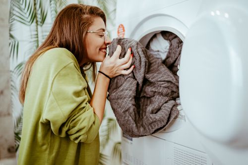 Woman Smelling Fresh Clean Towels