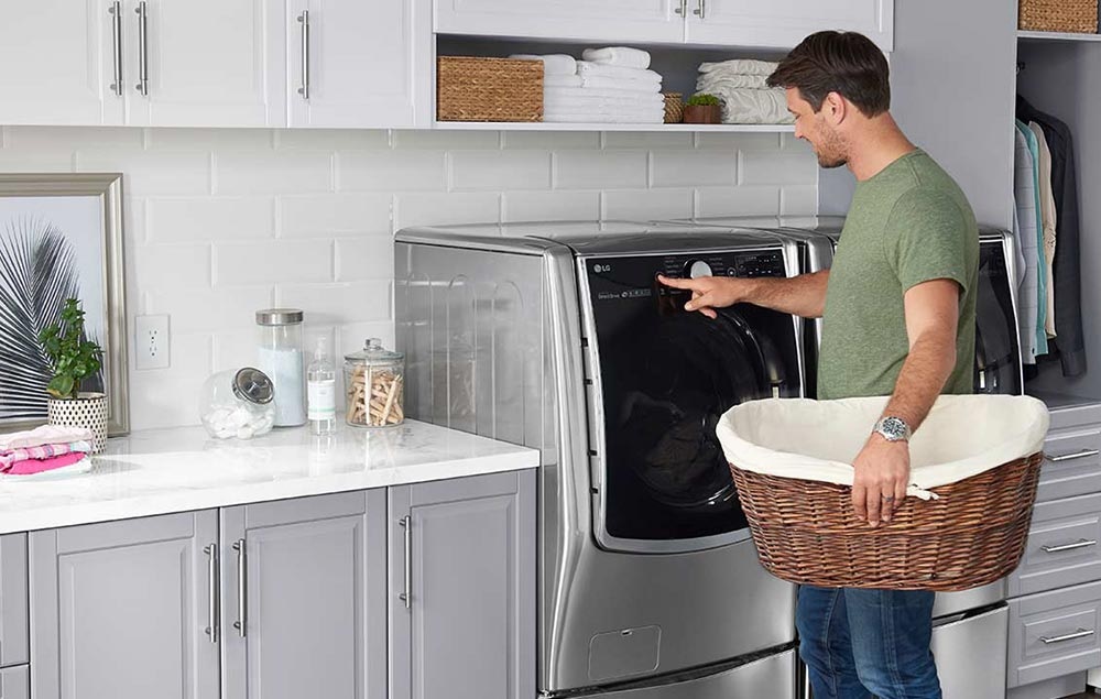 Source: lg.widencollective.com man uses electric front controls on LG electric dryer
