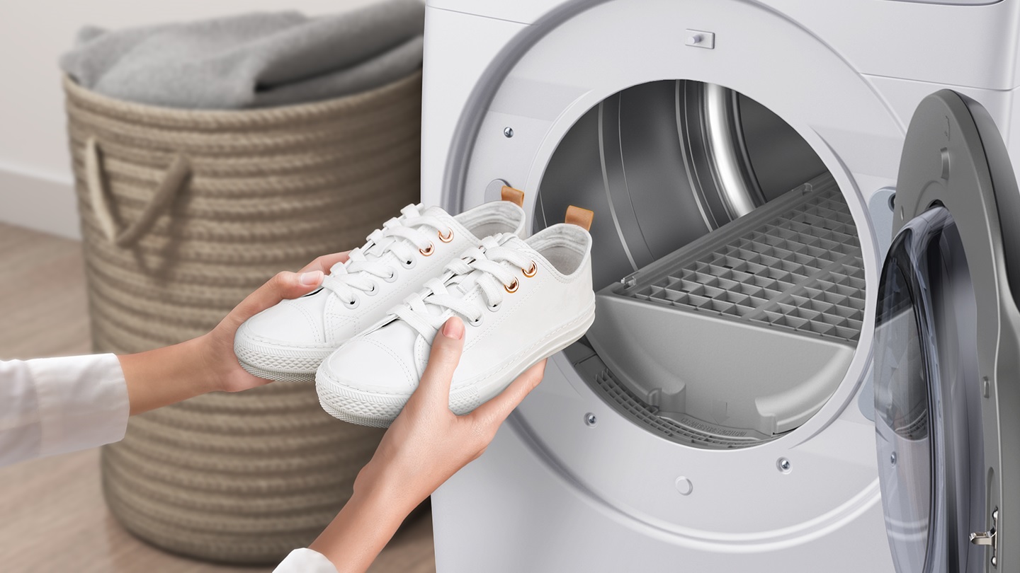 Source: dam.gettyimages.com/samsungeasyads woman retrieves cleaned white sneakers from Samsung gas dryer