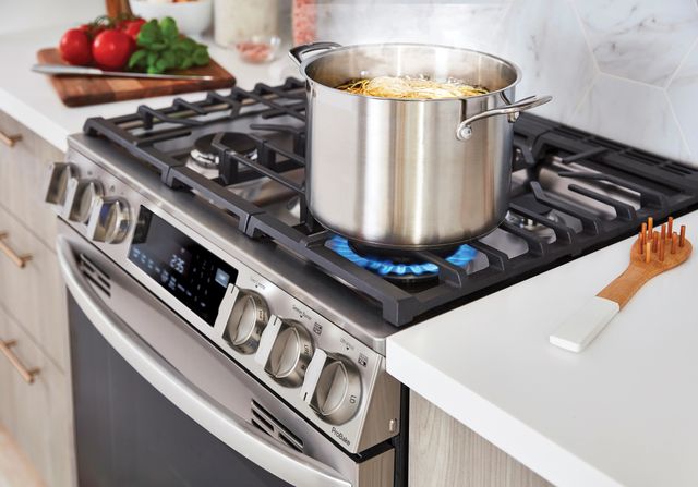 Close view of an LG gas stove with ProBake boiling a pot of pasta on top