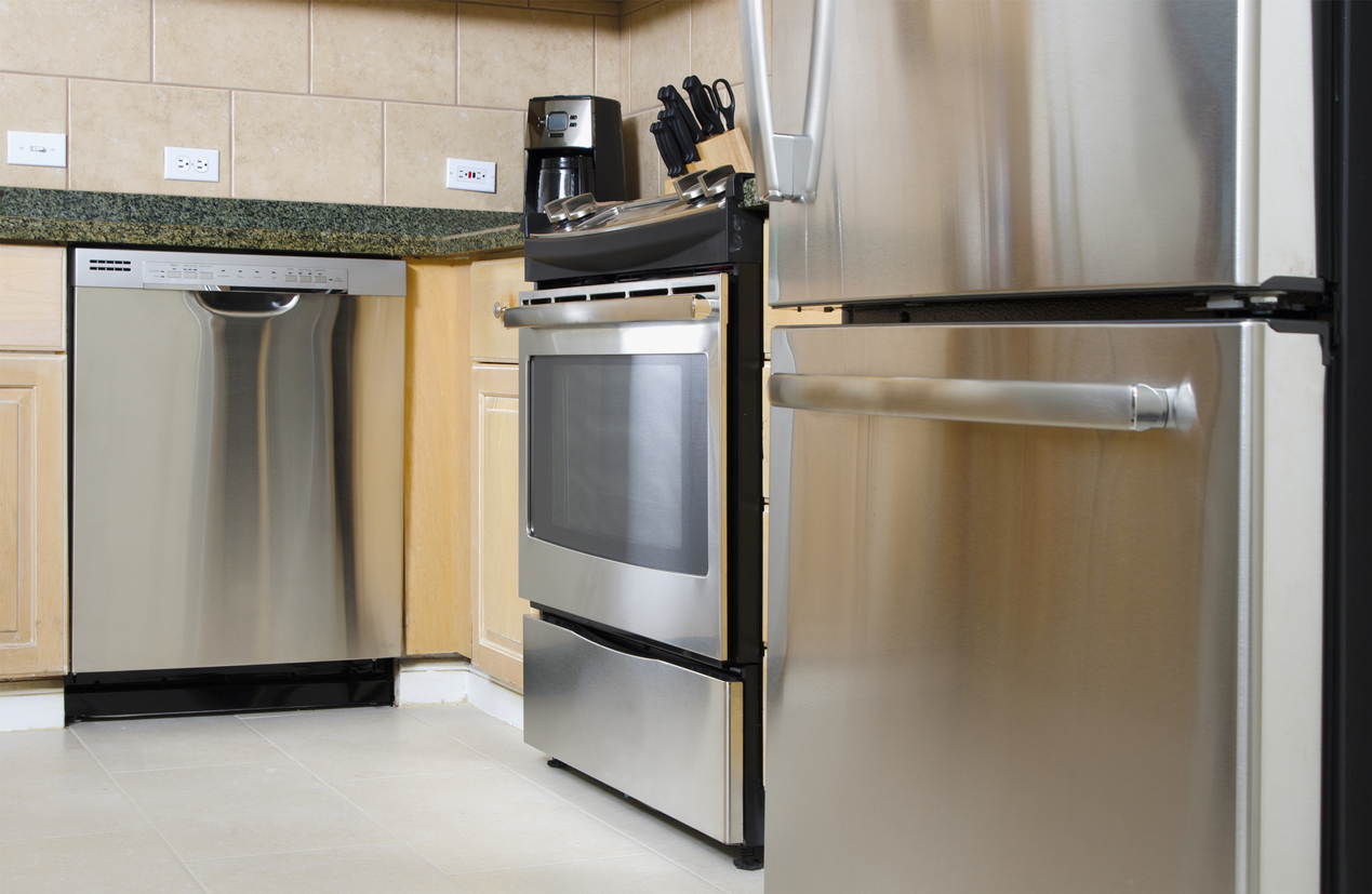 iStock Credit: bauhaus1000 Stainless-steel dishwasher, range, and bottom-freezer refrigerator installed into a kitchen