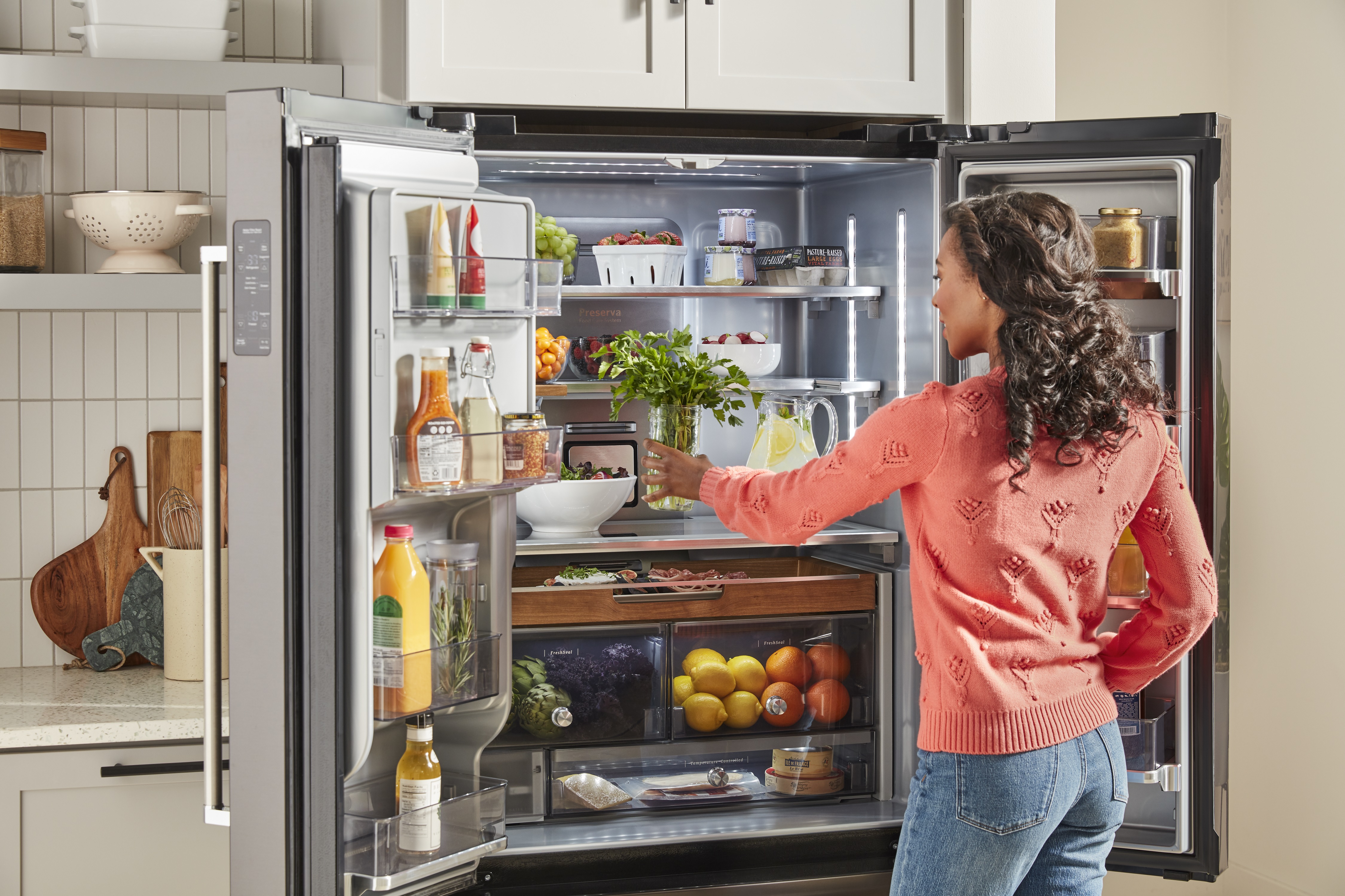 Credit: KitchenAid woman accesses inside of KitchenAid French door refrigerator
