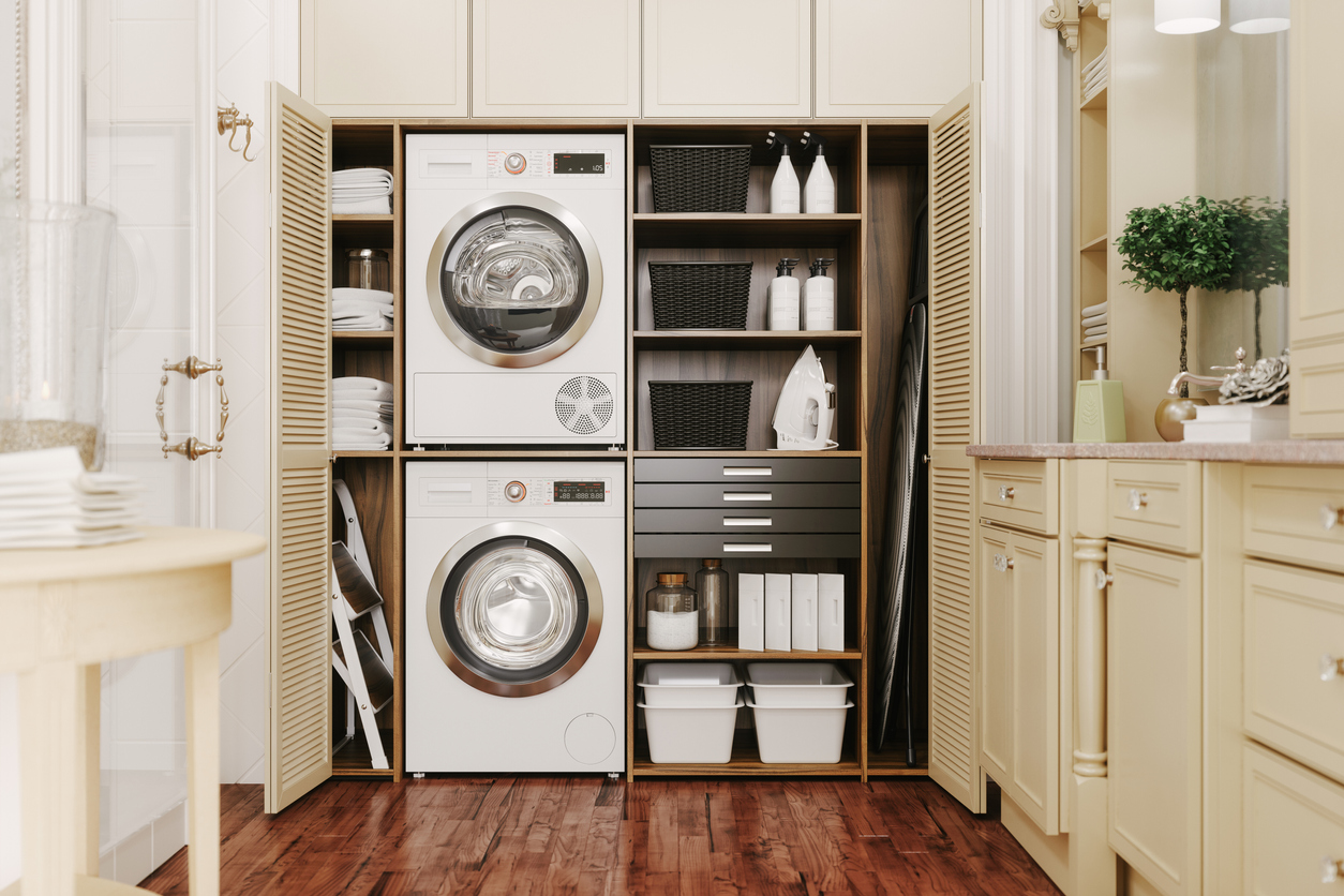 open freestanding closet revealing stackable washer and dryer and other laundry accessories