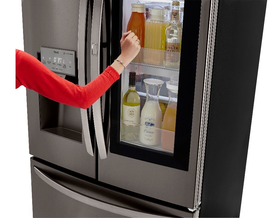 Credit: LG LG product image of woman using the French door refrigerator LFXS26596D InstaView™ Door-in-Door® feature