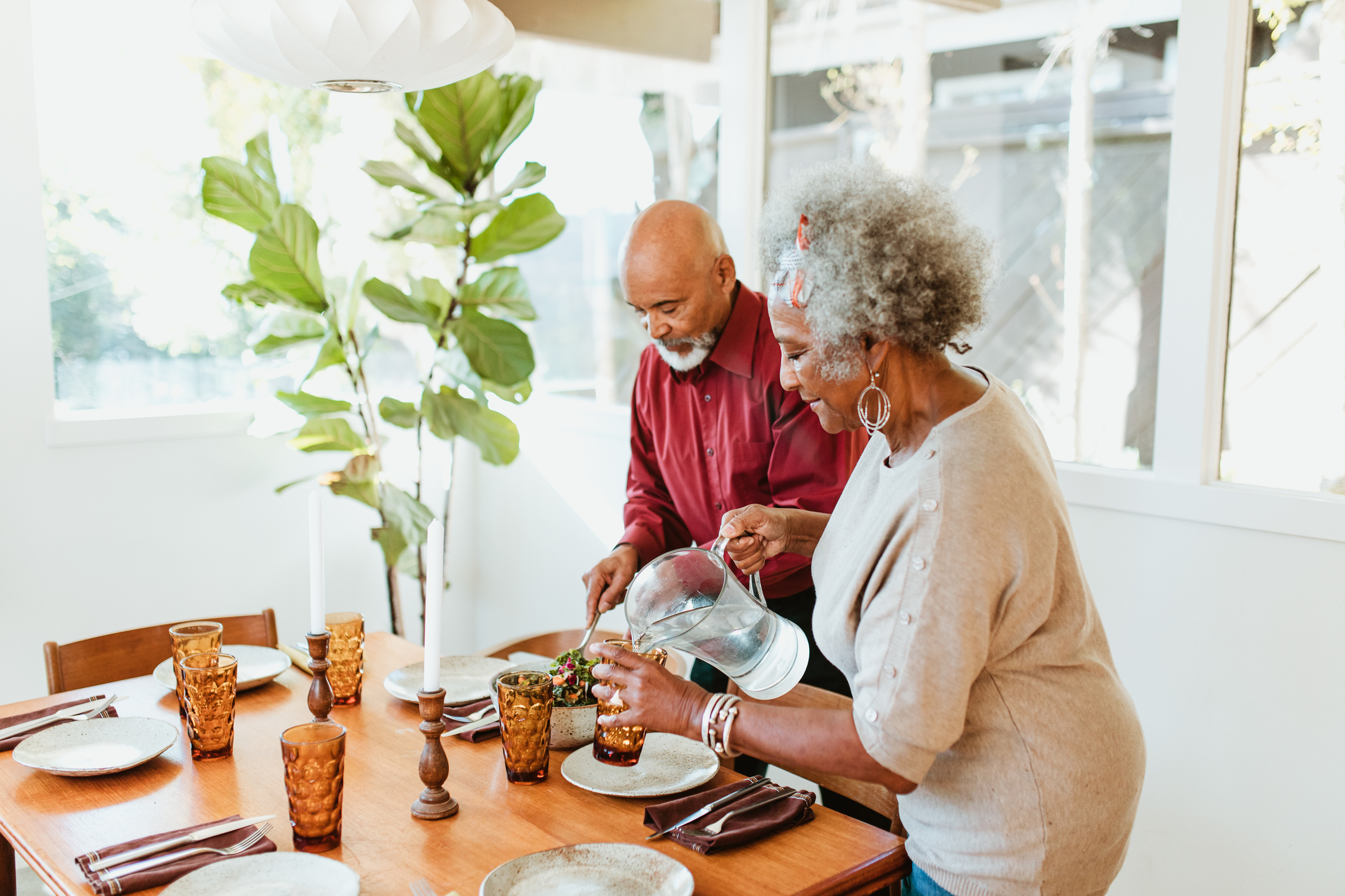 elderly couple pouring glasses of water