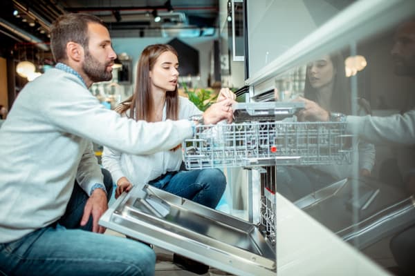 iStock Credit: Extreme Media A woman and a man inspecting a dishwasher in a store