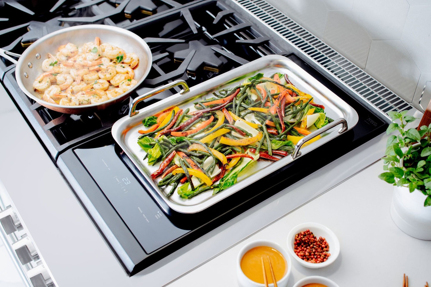 Credit: Thermador skillets of cooked peppers and shrimp on Thermador gas grates