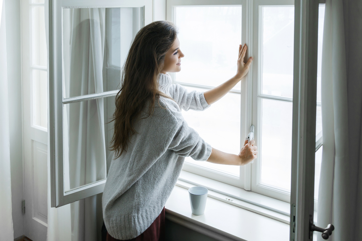 Credit:Jun Woman is opening window to look at beautiful snowy landscape outside
