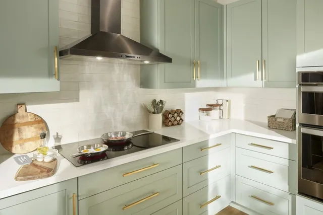 Front view of a modern kitchen with a Whirlpool electric cooktop and mint cabinetry