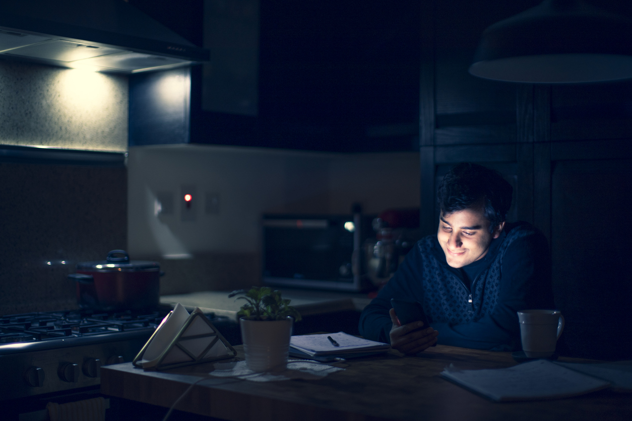 iStock Credit: GCShutter Young man taking a late night study break to be on his phone.