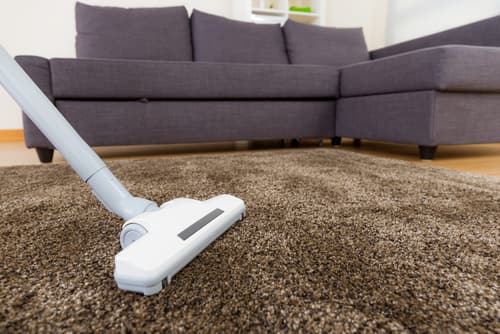 Homeowner holding central vacuum hose showing convenience Homeowner holding central vacuum hose showing convenience