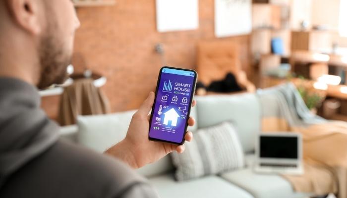 CI_Which-Smart-Devices-to-Buy_2.jpg Man using smart home system with phone