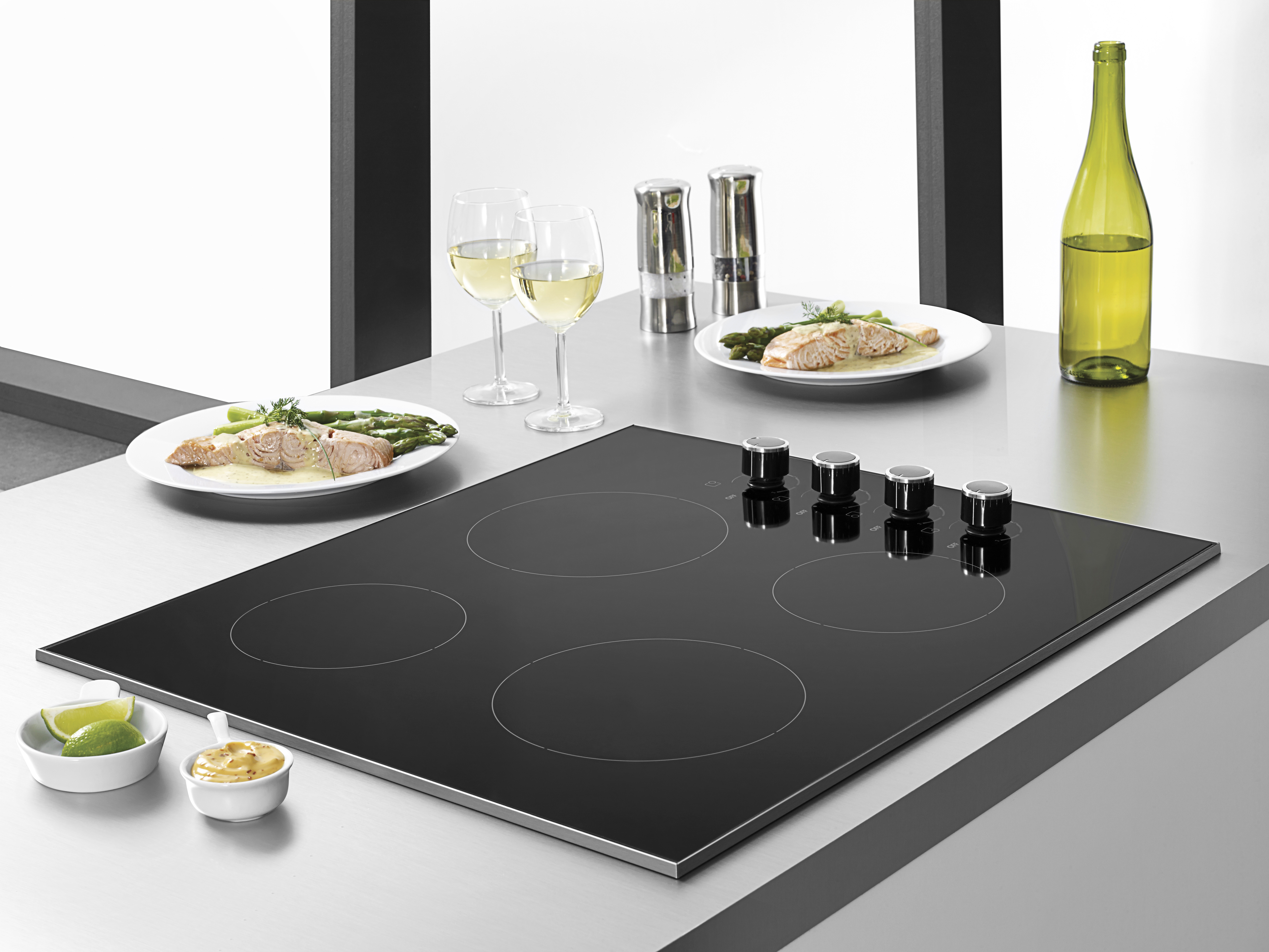 Overhead view of an induction style cooktop with a plate of salmon