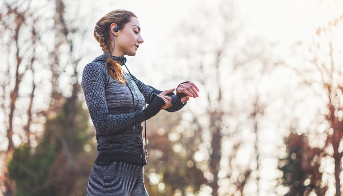 Elec_Springtime-Outdoor-Tech_4.jpg Woman wearing waterproof earphones and a fitness tracker while taking a springtime run