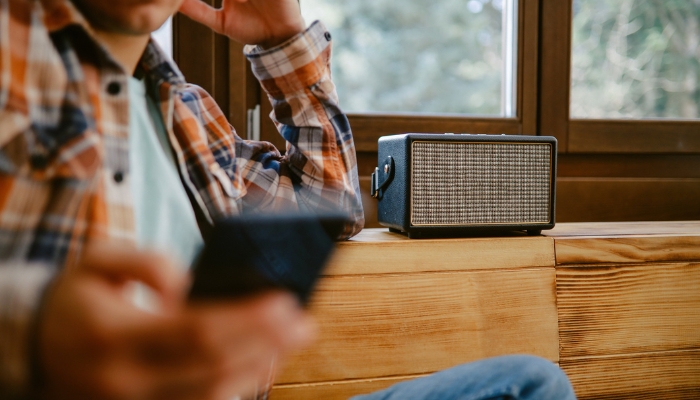 Elec_Music-Streaming-Audio-Quality_3.jpg Man streaming music through wireless speaker