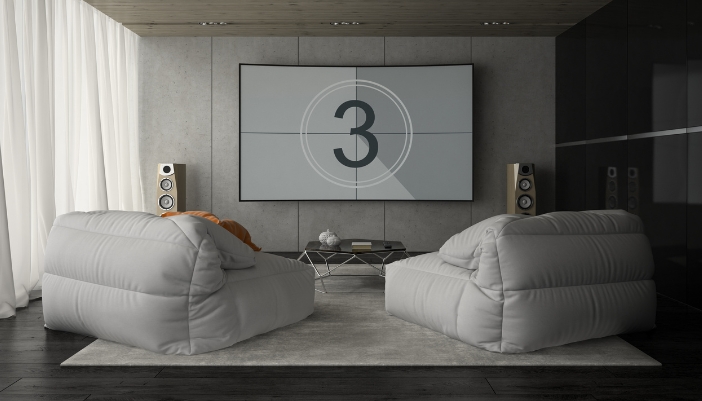 A living room with two floor standing speakers and a movie about to play