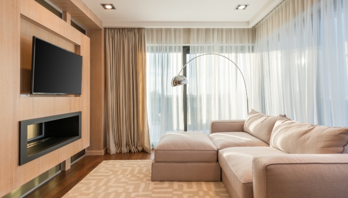 A living room setup with a wall-mounted TV and blackout curtains