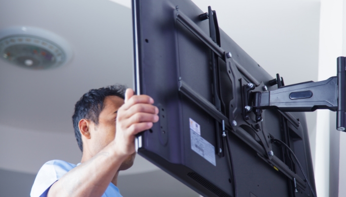 Elec_TV-Mounting-101_1.jpg A man extending his TV with a fully articulating wall mount
