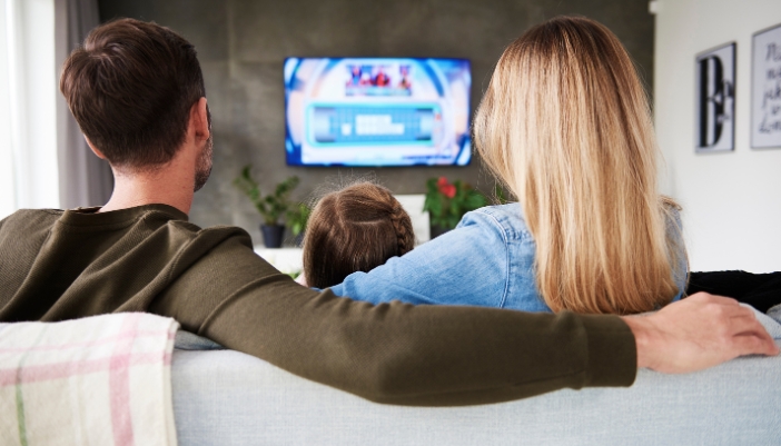 Elec_TV-Mounting-101_5.jpg Family watching TV that is mounted on the wall