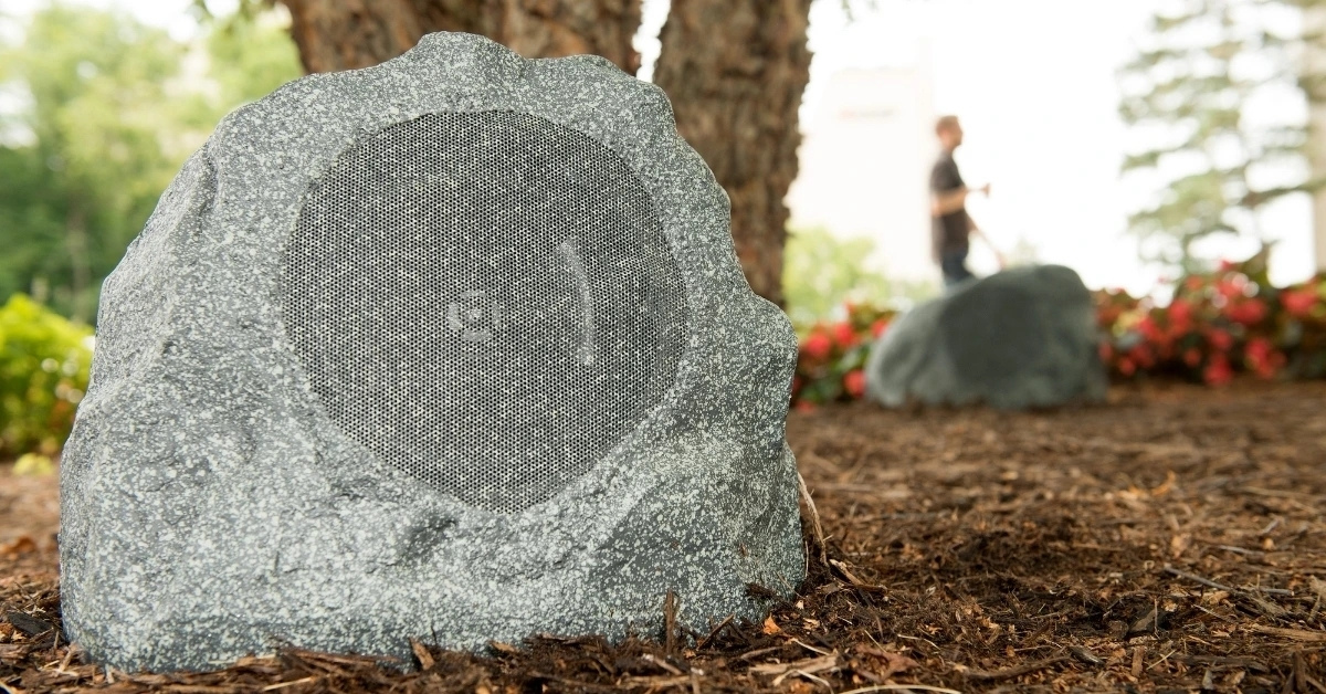 A Klipsch outdoor rock speaker in a garden 