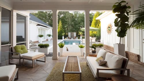 A large patio structure with built in architectural shades lowered against the sunset
