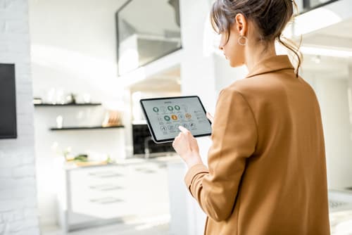Smart home control app interface on a tablet showing environmental controls