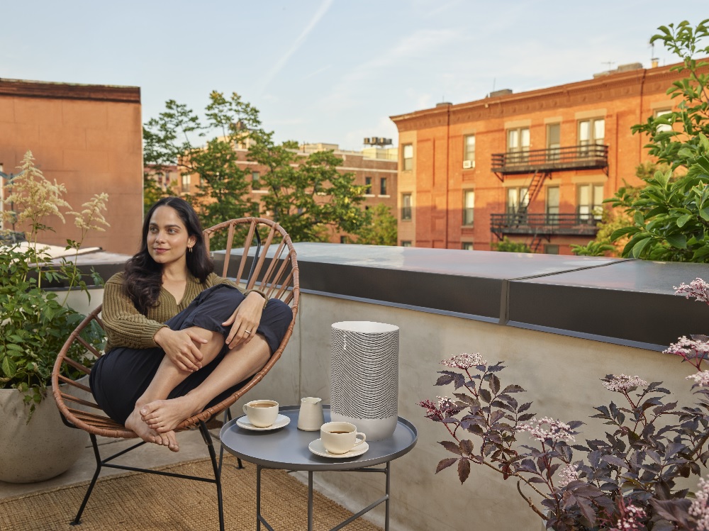 woman looks peaceful while listening to music on Sonos Move speaker on terrace