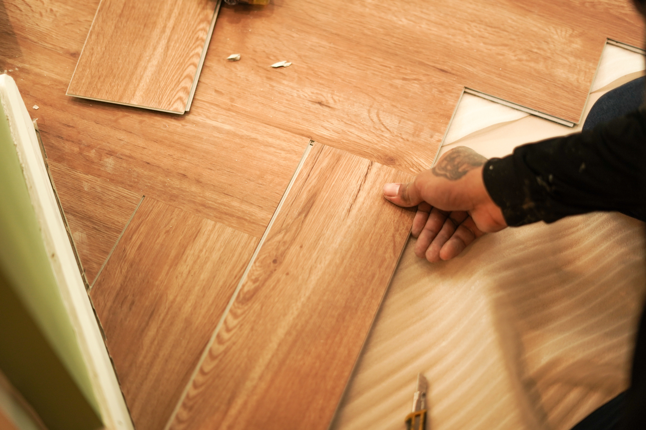 A person installing vinyl plank flooring