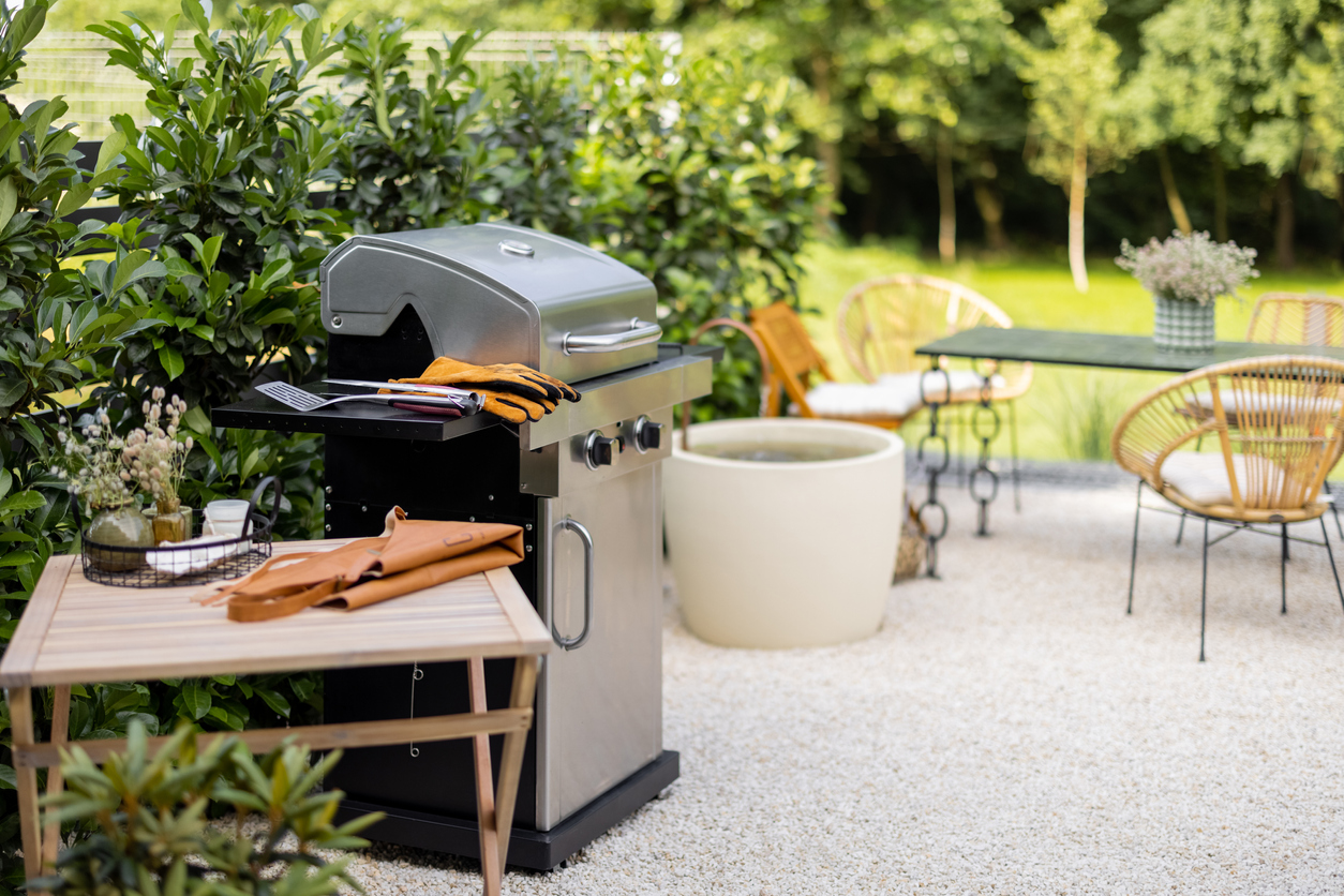 Beautiful backyard with a freestanding grill and dining table. 
