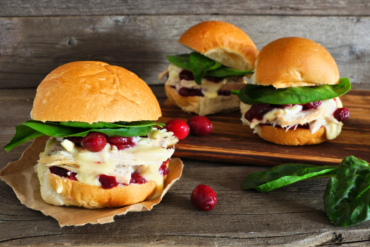 iStock Credit: jenifoto roasted turkey sandwiches with cranberry sauce and cheese against wood
