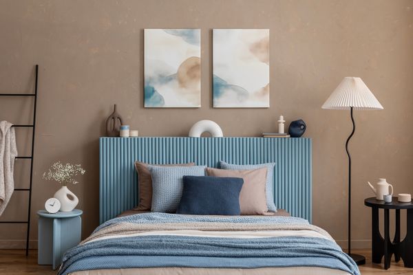 iStock Credit: FollowTheFlow A coastal-style blue panel bed with décor in a bedroom