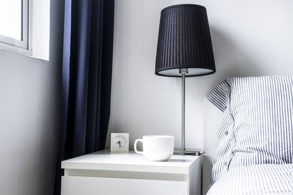 A close-up of a modern white nightstand with décor 